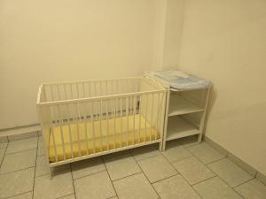 a baby crib in a corner of a room at Herzensplatzl in Pfaffenhofen