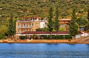 a large building sitting on the side of a lake at Baba Veli Pension in Kaleucagız