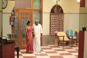 a man and a woman standing in a room at Chettinaadu Narayana Inn in Kānādukāttān