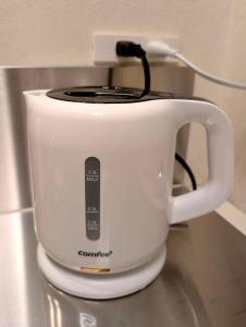 a white slow cooker sitting on top of a counter at yucurum in Itoman