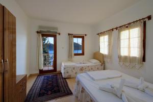 ein Schlafzimmer mit zwei Betten und zwei Fenstern in der Unterkunft Baba Veli Pension in Kaleucagız