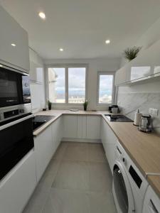a kitchen with white cabinets and a stove top oven at Centre-ville de Saint-Brieuc in Saint-Brieuc