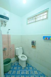 a bathroom with a toilet and a shower in it at Homestay Alkid in Timuran
