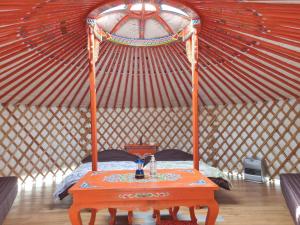 a bed in a yurt with a table in it at モンゴルゲルグランピング Frontier Village in Tōma