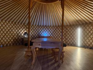 a room with a wooden table in a yurt at モンゴルゲルグランピング Frontier Village in Tōma