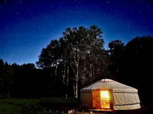a yurt with a light in a field at night at モンゴルゲルグランピング Frontier Village in Tōma