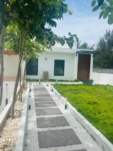 a walkway in front of a house with trees at VB beach Villa at ECR mugaiyur in Kūvattūr +5 photos