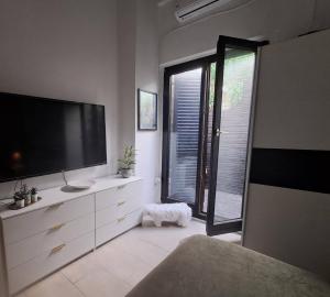 a living room with a large television and a window at The Village Retreat in Malona Village
