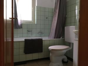 a bathroom with a toilet and a tub and a sink at Chalet Wildbach in Adelboden