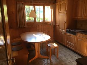 kuchnia z drewnianym stołem, małym stołem i stołkiem w obiekcie Chalet Wildbach w mieście Adelboden