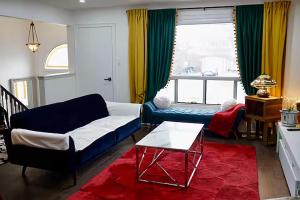 a living room with a blue couch and a red rug at Private Bedroom with Ensuite in Toronto