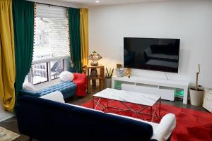 a living room with a couch and a flat screen tv at Private Bedroom with Ensuite in Toronto