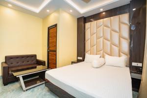 a bedroom with a bed and a chair at Mahabhoj Hotel & Restaurant in Mandarmoni
