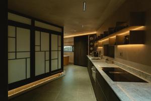 a kitchen with black cabinets and a large window at Achroma de Hanok in Seogwipo