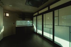 an empty room with glass doors and a window at Achroma de Hanok in Seogwipo