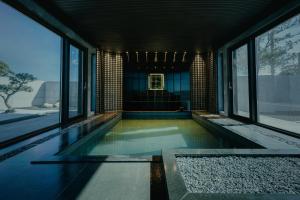 a swimming pool in a building with windows at Achroma de Hanok in Seogwipo