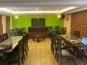 a dining room with green walls and tables and chairs at Hotel Malla Inn in Bhaktapur