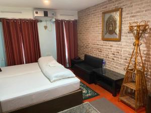 a bedroom with a bed and a chair and a table at Hotel Malla Inn in Bhaktapur +8 photos