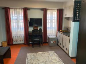 a living room with a desk and a television and red curtains at Hotel Malla Inn in Bhaktapur