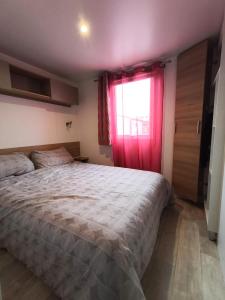 a bedroom with a bed and a red window at Eucalyptus 24 du samedi au samedi location in Valras-Plage