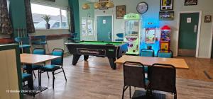 a billiard room with a pool table and tables and chairs at Island Butterfly haven in Sandown