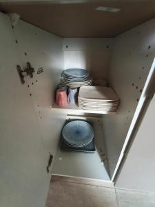 a kitchen with plates and dishes on a shelf at Eucalyptus 24 du samedi au samedi location in Valras-Plage