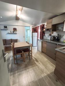 a kitchen and dining room with a table and a couch at Eucalyptus 24 du samedi au samedi location in Valras-Plage