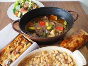 a table with a pot of soup and a plate of food at 国登録有形文化財の宿 Hotel 旧若林邸 in Sado +12 photos