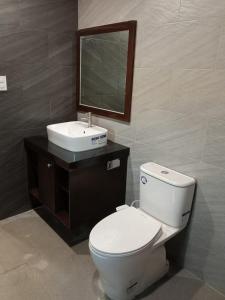 a bathroom with a toilet and a sink and a mirror at Top Star Hotel Manaoag in Manaoag