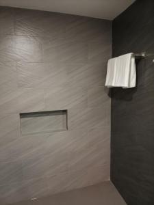 a bathroom with a shower with a white towel at Top Star Hotel Manaoag in Manaoag