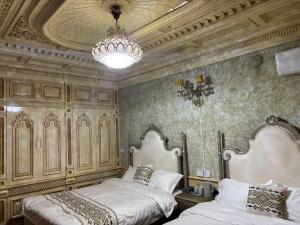 a bedroom with two beds and a chandelier at 梵雅民宿Fanya in Kashgar
