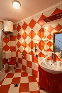 a bathroom with a checkered floor and a sink at Villa del Mare in Dobra Voda