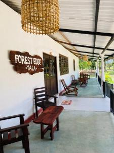 a porch with wooden benches and a chandelier at Forest Edge Yala Resort in Gotamegama