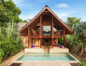 een huis met een zwembad ervoor bij Jetwing Vil Uyana in Sigiriya