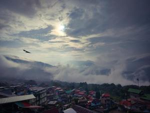 a plane flying in the sky over a city at Mayuri Lodge in Kalimpong