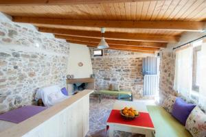 a living room with a couch and a table at Orgon Farm Village Houses in Apóstoloi