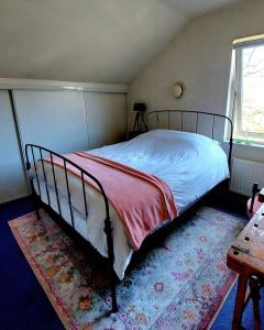 a bedroom with a bed and a table and a window at Carmen's Stay In - Dichtbij Amsterdam- Jaagweg 13 - Ilpendam in Ilpendam