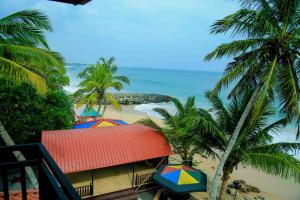 vistas a una playa con palmeras y al océano en Gayana Guest House, en Tangalle