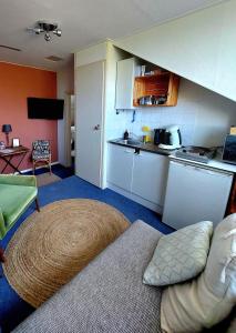 a living room with a couch and a kitchen at Carmen's Stay In - Dichtbij Amsterdam- Jaagweg 13 - Ilpendam in Ilpendam