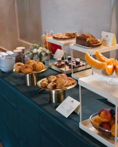 a table with plates of pastries and other desserts at Relais Corte Baruzzo in Volta Mantovana