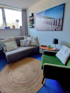 a living room with a couch and a table at Carmen's Stay In - Dichtbij Amsterdam- Jaagweg 13 - Ilpendam in Ilpendam