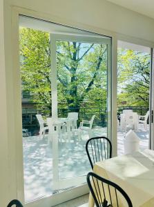 a patio with white tables and chairs and a sliding glass door at Hotel Anversa Rimini in Rimini