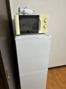 a microwave sitting on top of a refrigerator at 馨誠小屋201 in Tokyo