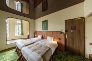 a bedroom with a large bed and a large window at T9 Hakodate in Hakodate