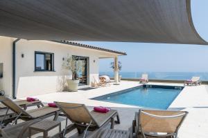 a villa with a swimming pool and a patio at villa mare d'argentu - vue mer panoramique in Sari Solenzara