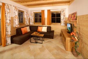 a living room with a couch and a tv at Bio Chalet "Sonne" in Weisspriach