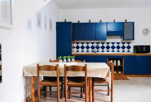 a kitchen with a table with chairs and blue cabinets at ALMA'RE Le Trame di KaSa Experience in Porto Ottiolu