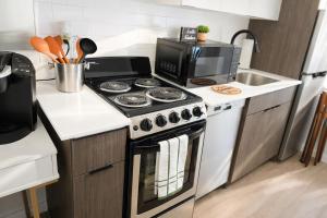 a kitchen with a stove top oven next to a sink at Cozy Studio Downtown Detroit in Detroit