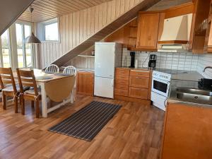 a kitchen with a table and a white refrigerator at Sommartornsgård in Munkedal