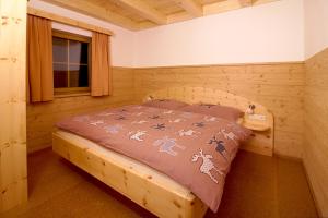 ein Schlafzimmer mit einem Bett in einem Holzzimmer in der Unterkunft Bio Chalet "Sonne" in Weisspriach